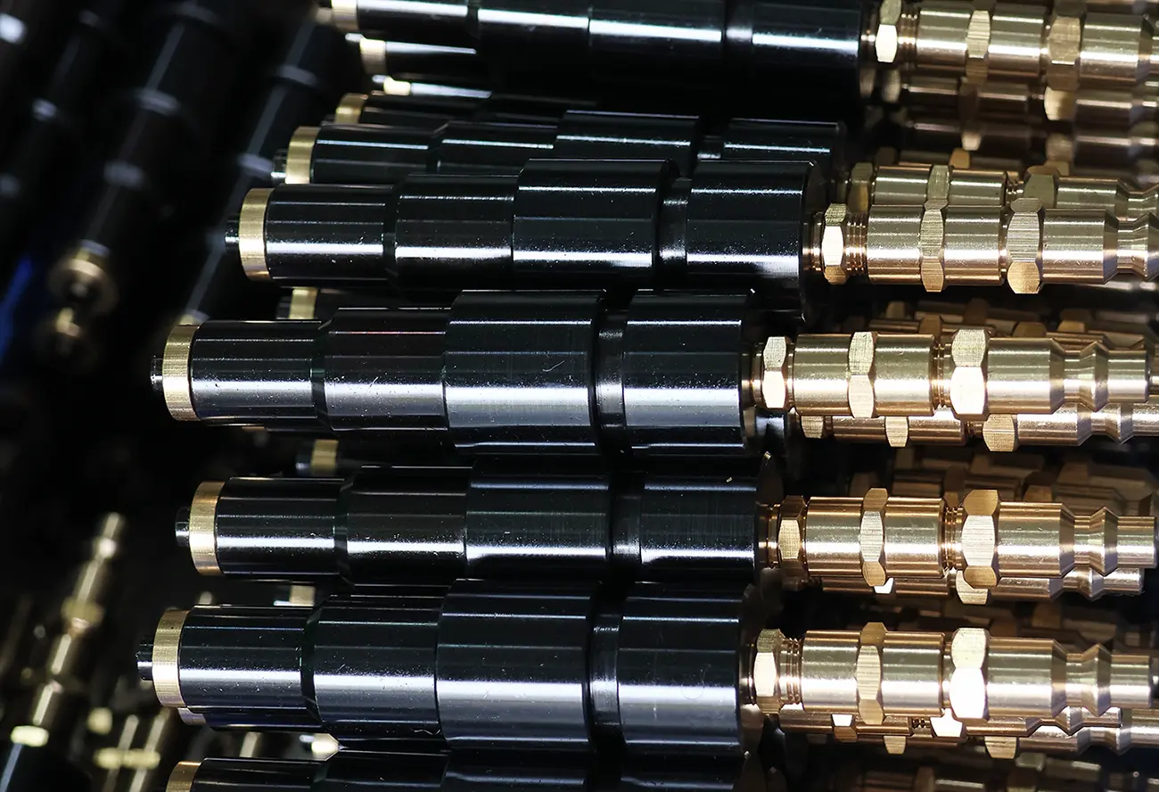 Polished custom stamped metal hardware components used on bowling alley amusement equipment