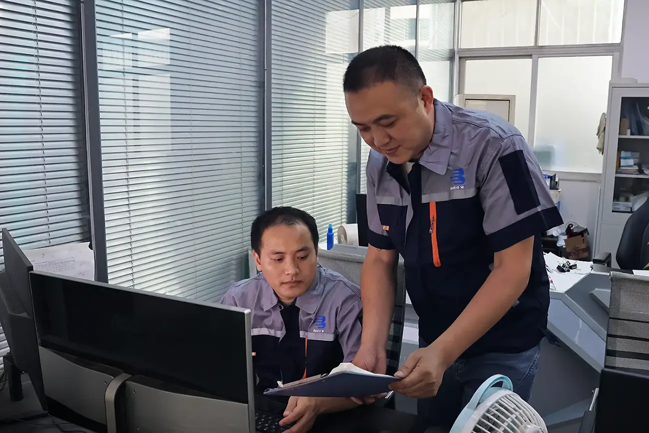 Engineering team discussing custom metal parts projects in the office