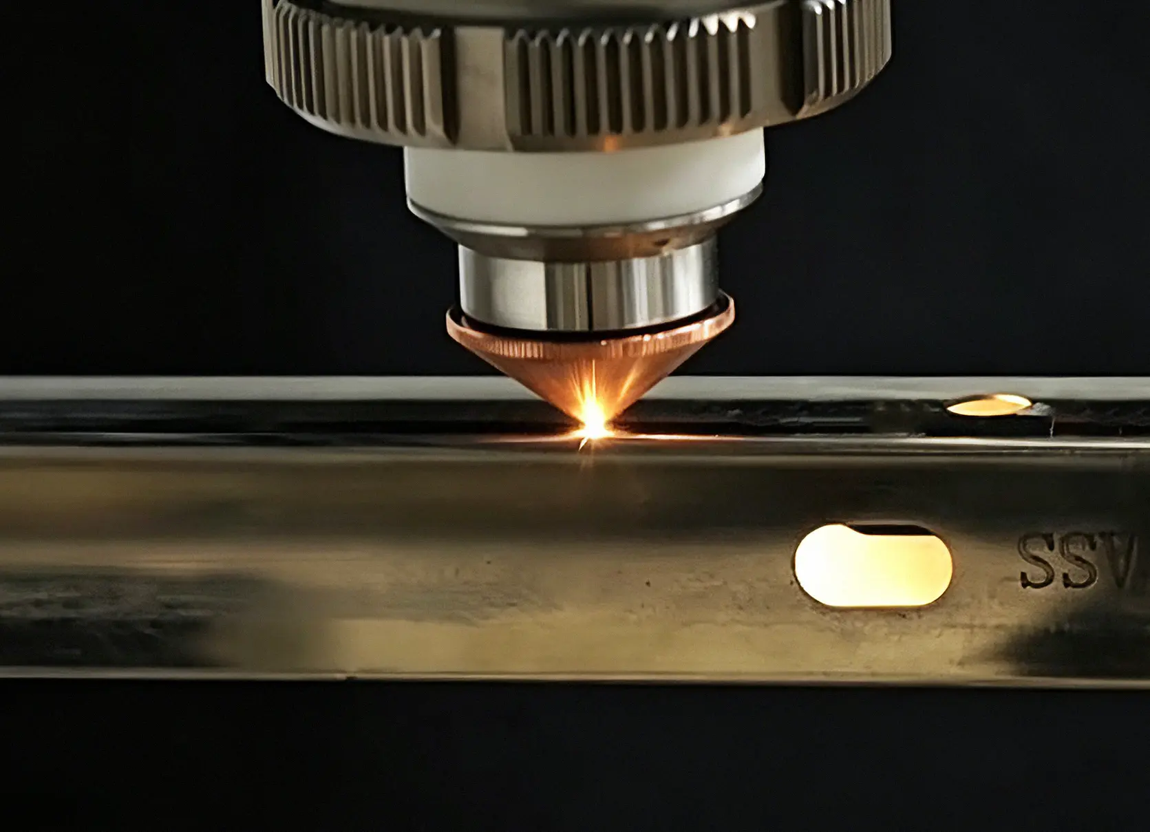 CNC laser cutting machine producing perforated stainless steel architectural panels.