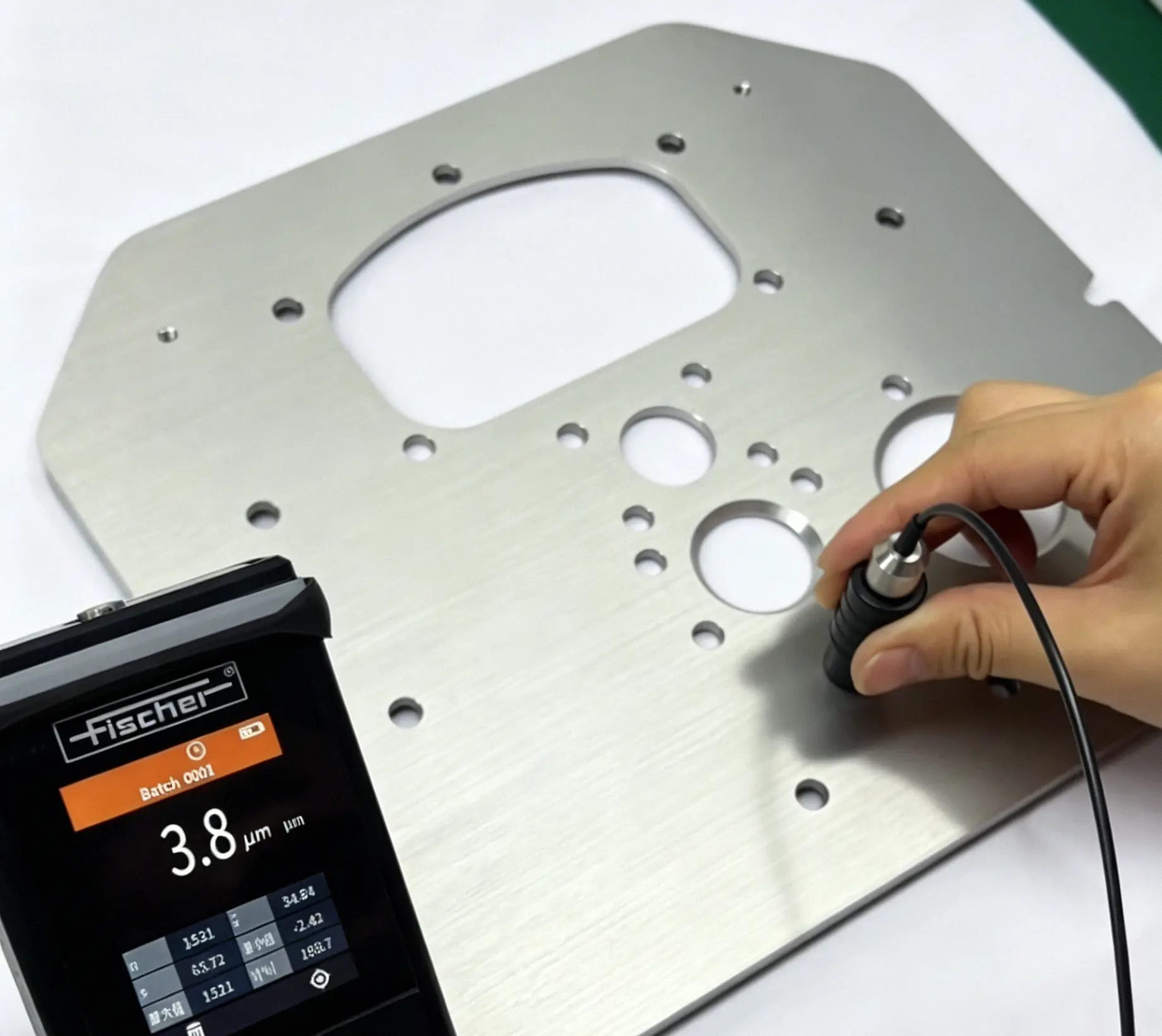Fischer hardness coating thickness tester inspecting custom CNC machined aluminum sheet metal plate, material hardness verification for heat treated high strength metal parts manufacturing quality assurance