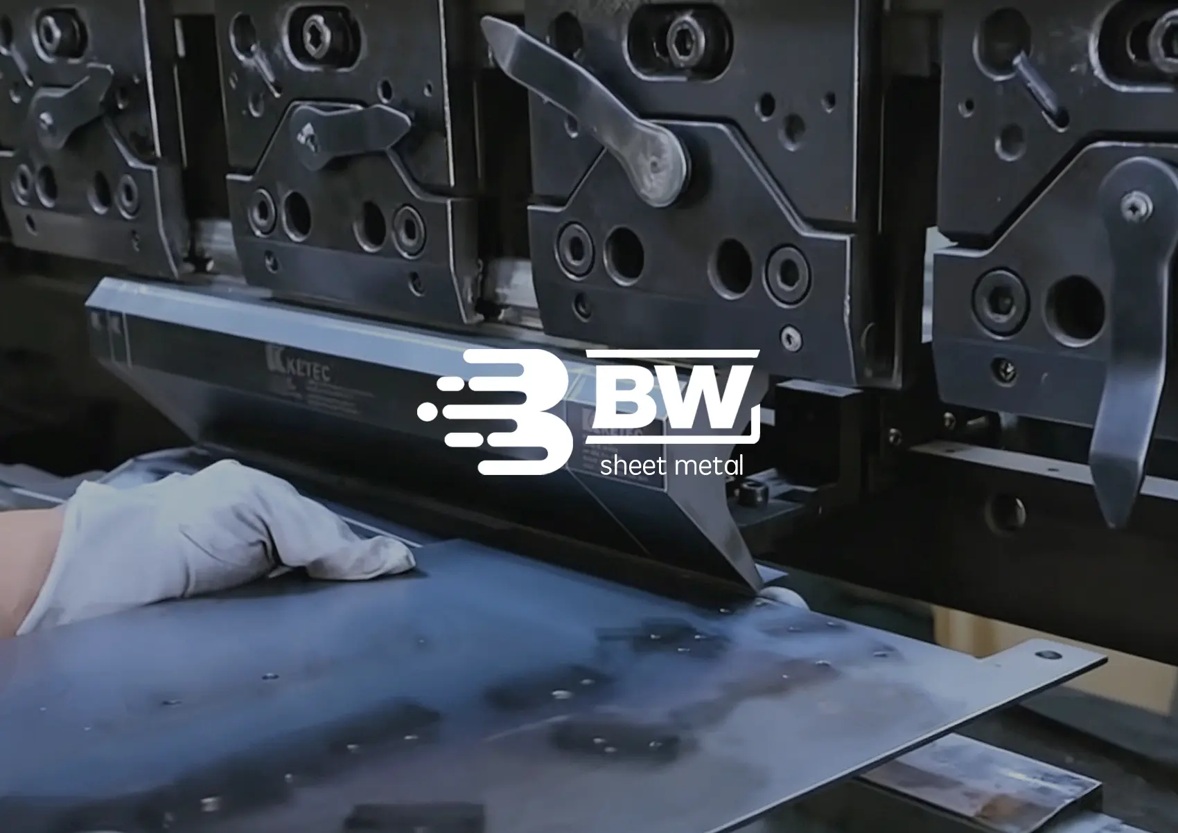 Operator forming a metal sheet on a CNC press brake
