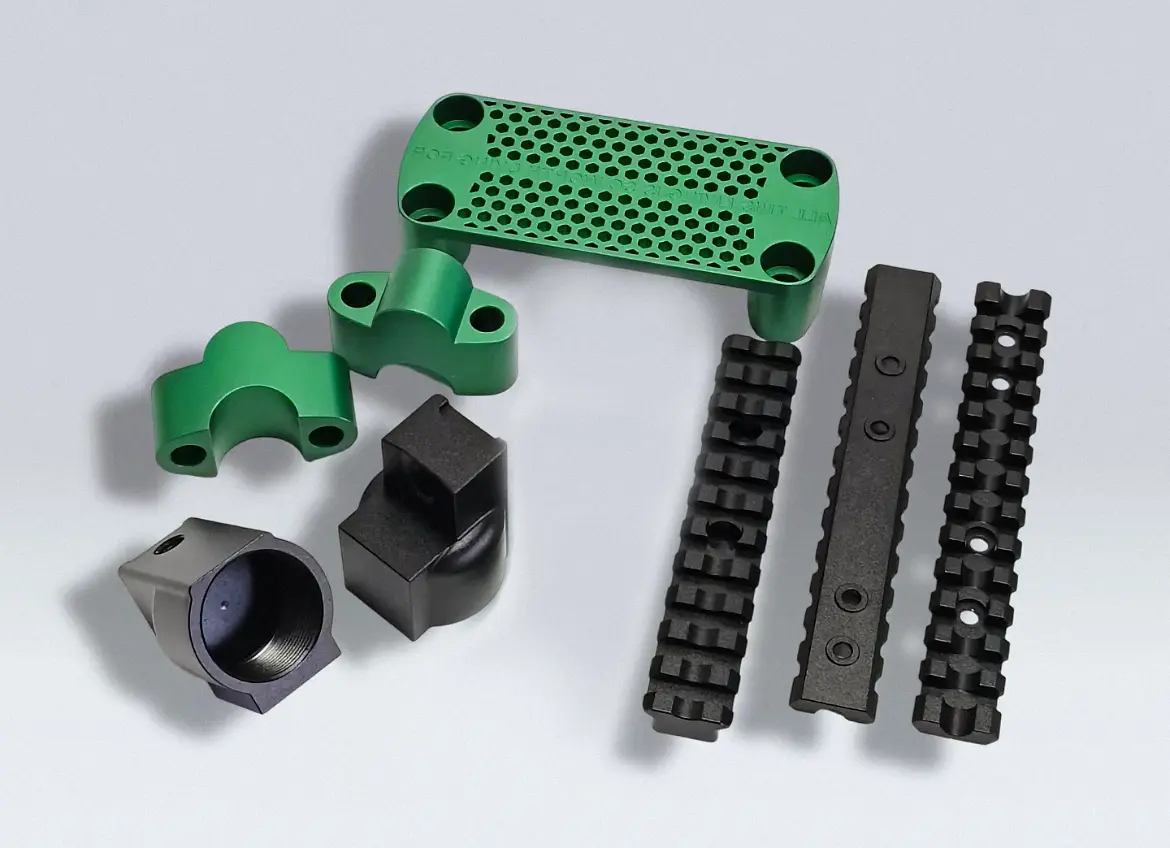 CNC-milled aluminum plates and brackets with green and black anodized finishes