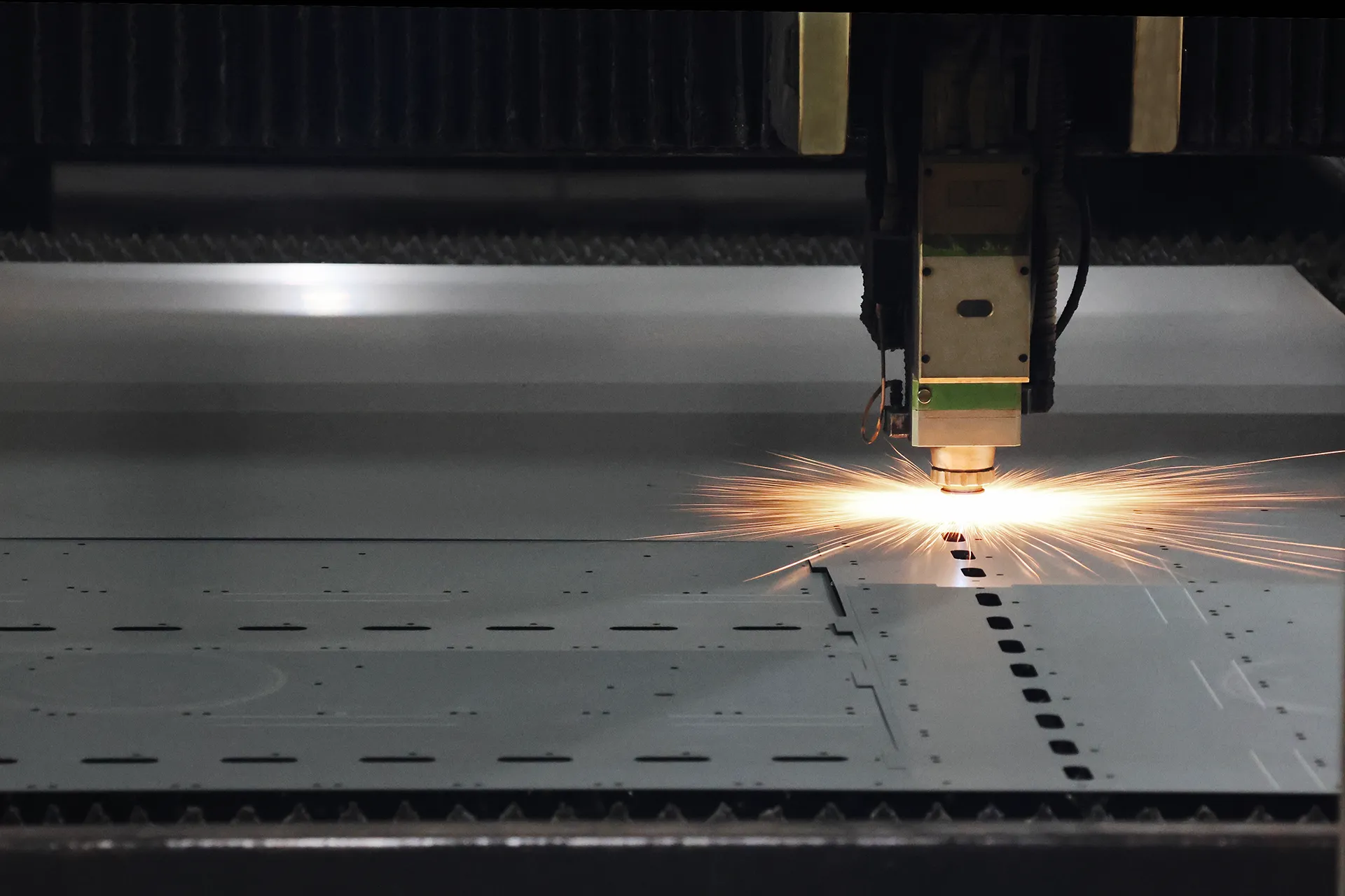 CNC fiber laser cutting machine processing sheet metal with sparks