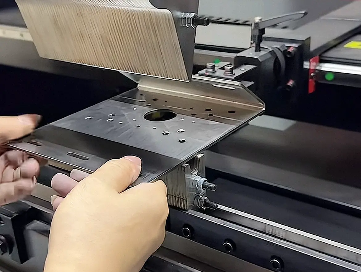 CNC press brake machine bending custom stainless steel sheet metal part during fabrication process
